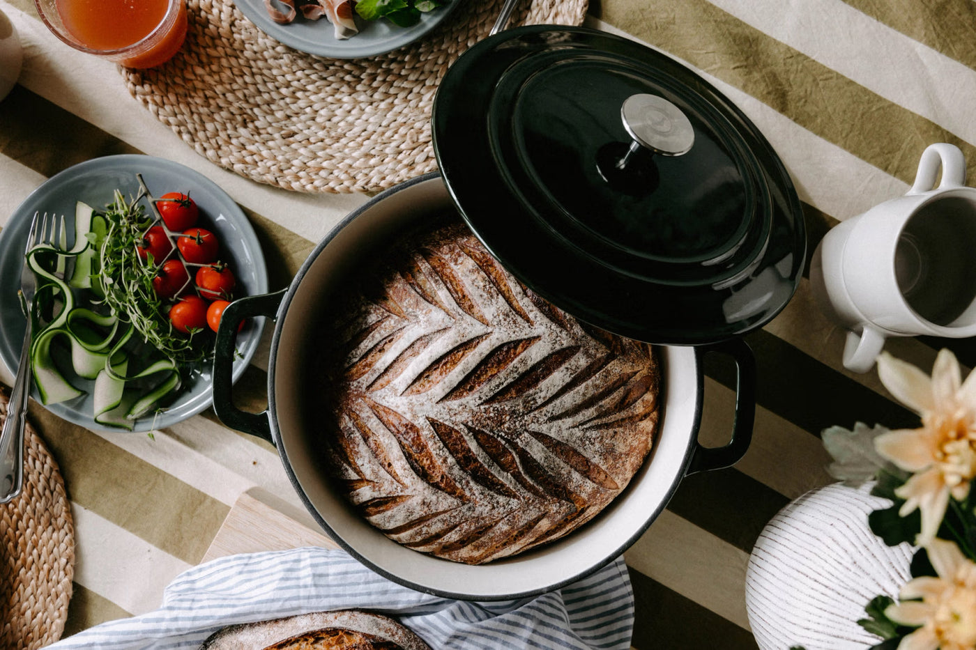 Brödbak i gjutjärnsgryta från Anders Petter – rustik gryta med lock, serverad på dukat bord med färska grönsaker och bröd.