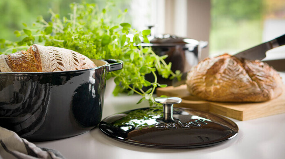 Gjutjärnsgryta från Sabor i svart emalj med nybakat bröd – funktionell och stilren design för det skandinaviska köket.