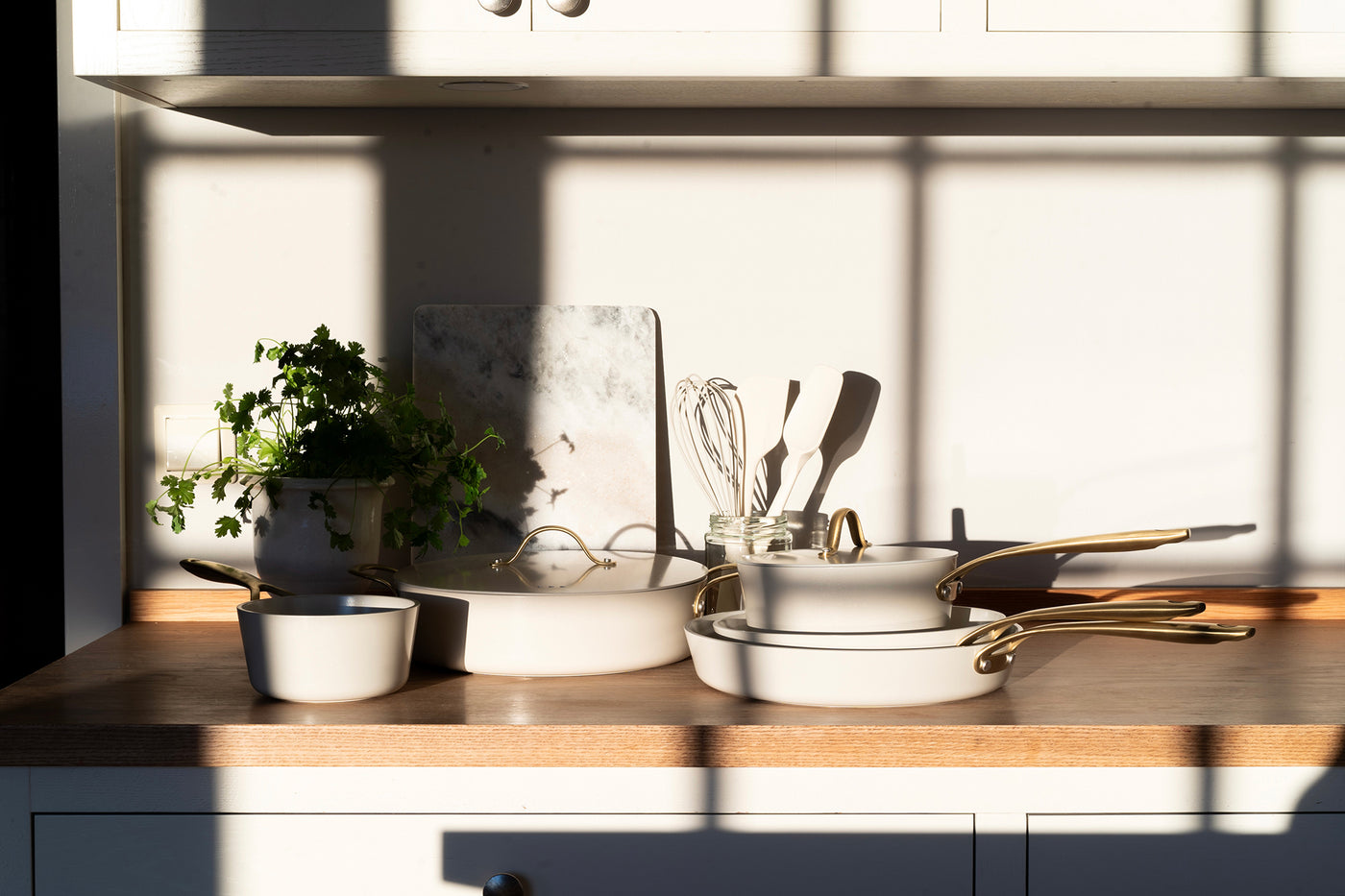 Heirol Royal Pearl stekpanna i elegant design placerad på en vit köksbänk med beige textilier och rustika detaljer.